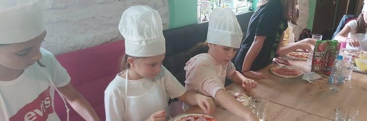 uczniowie klasy czwrtej dzielący w pizzeri pizzę na kawałki, nauka ułamków