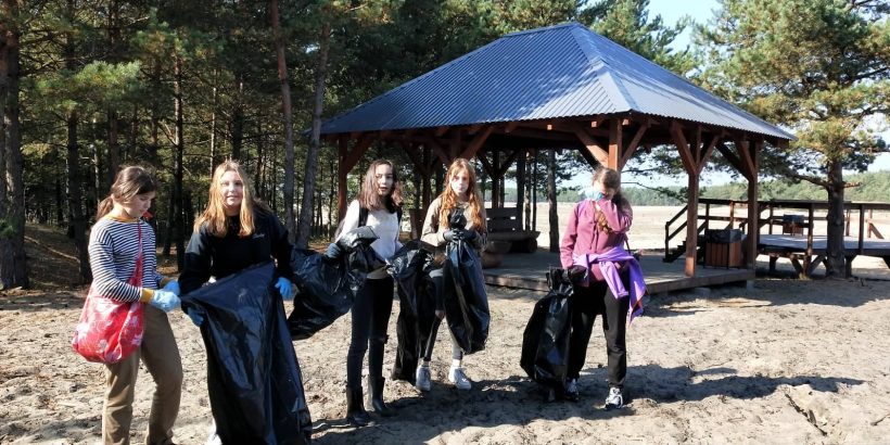 uczennica na pustyni z workami na śmieci, sprzątają naszą gminę