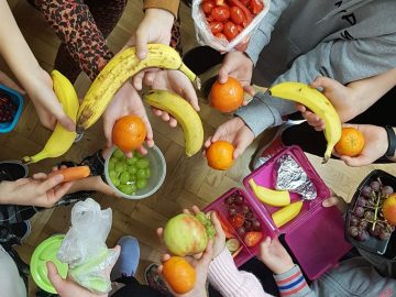 warzywa i owoce w dłoniach uczniów