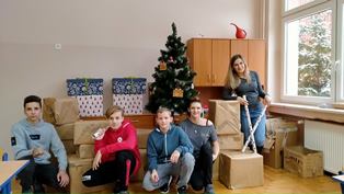 Uczniowie wolontariusze i nauczyciele pakujący dary dla rodziny