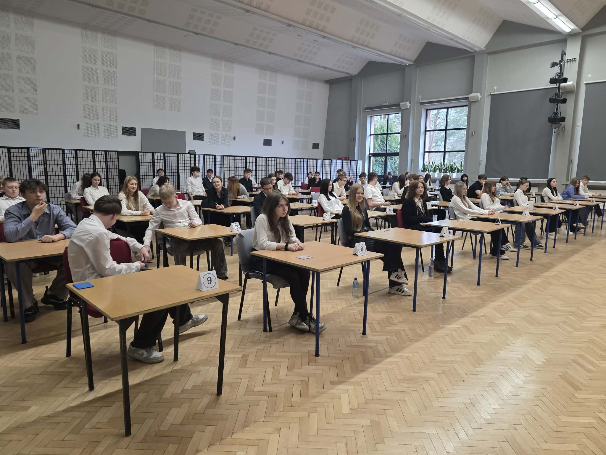 Próbne egzaminy ósmoklasisty w naszej szkole, uczniowie piszący egzamin w auli szkolnej