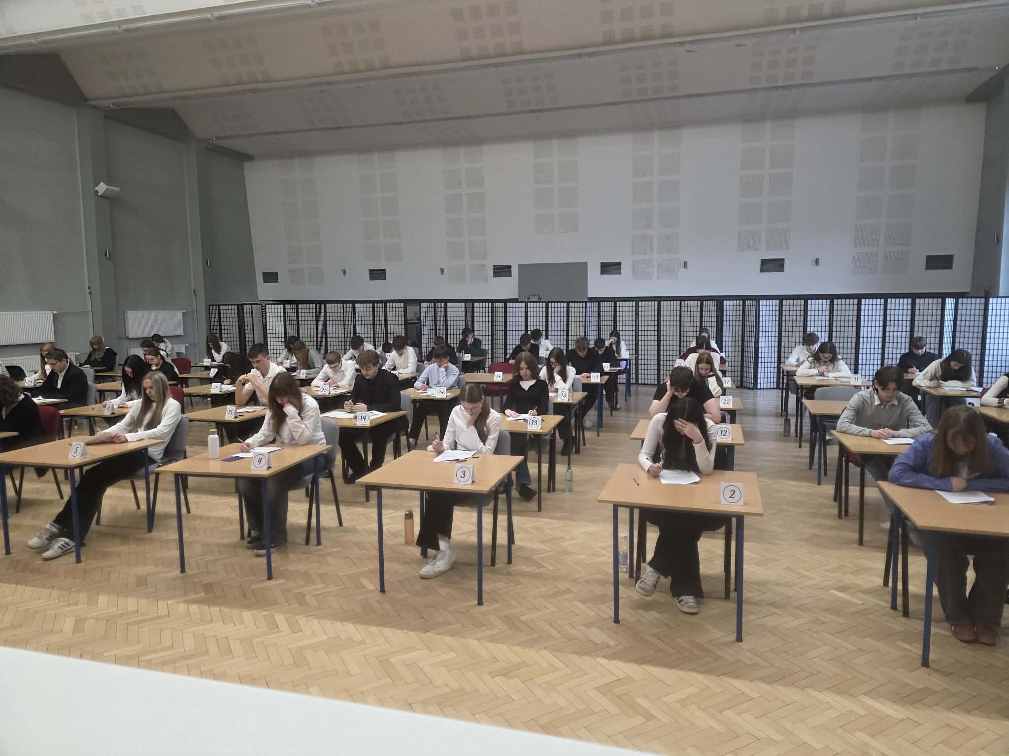 Próbne egzaminy ósmoklasisty w naszej szkole, uczniowie piszący egzamin w auli szkolnej